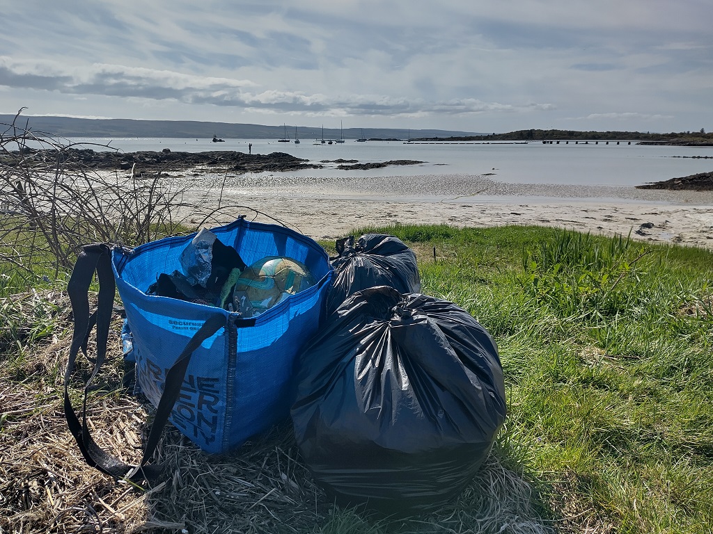 Some bags of rubbish with a sunny sea view in the background